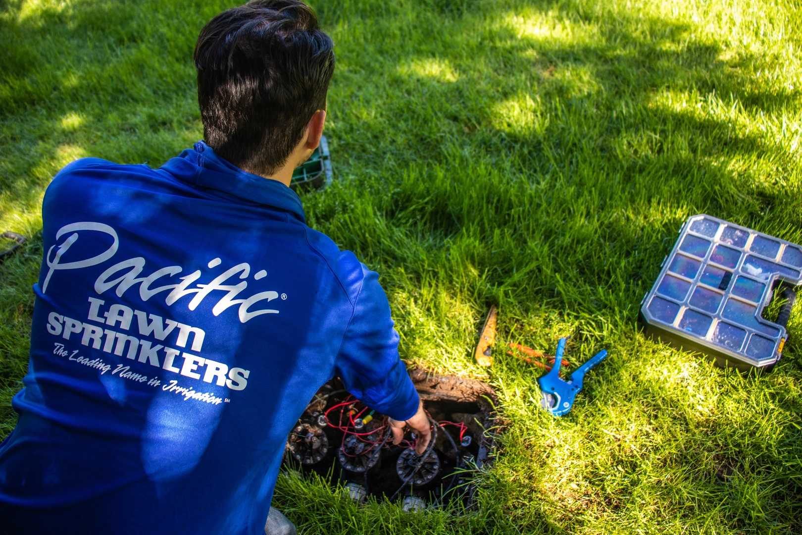 Technician repairing a branded irrigation system